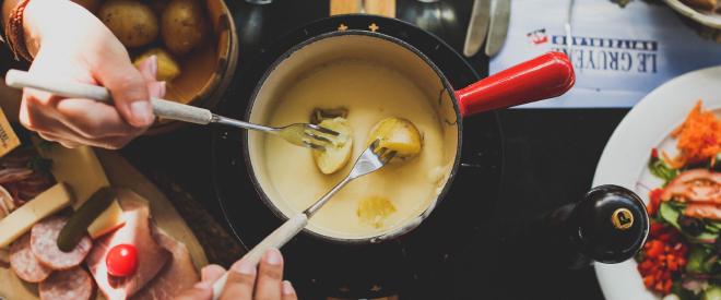 Ein Caquelon mit Fondue und Beilagen